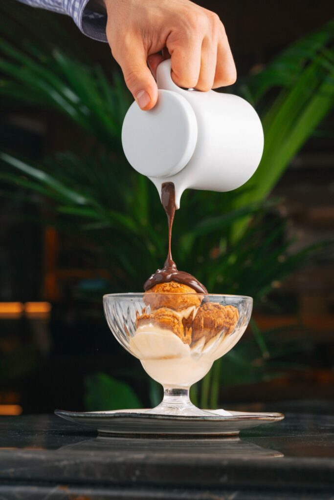 Hot chocolate sauce poured over ice cream