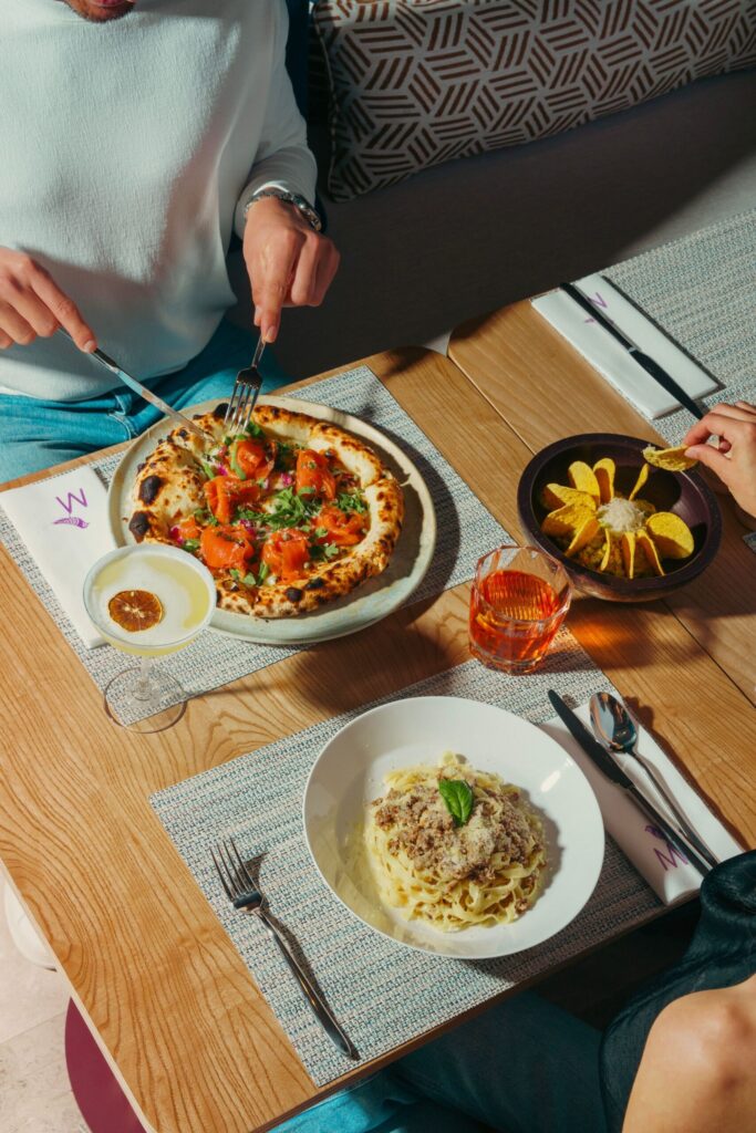 Table with pizza and pasta, seen from above