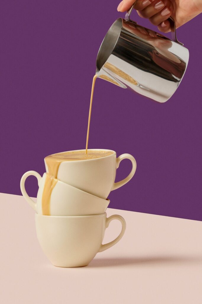 Milk being poured into stacked cups
