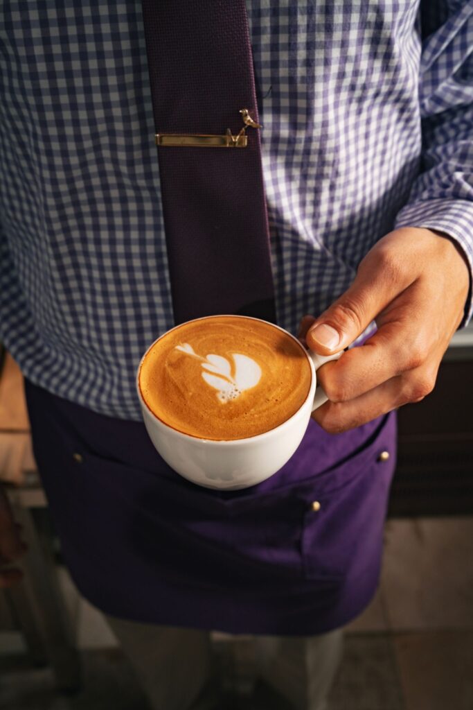 Waiter holding a latte with latte art