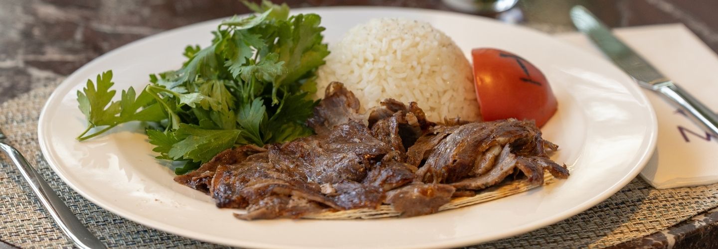 Grilled meat plate with rice and roasted tomato