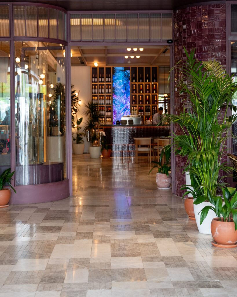 Marble-floored entrance lined with plants