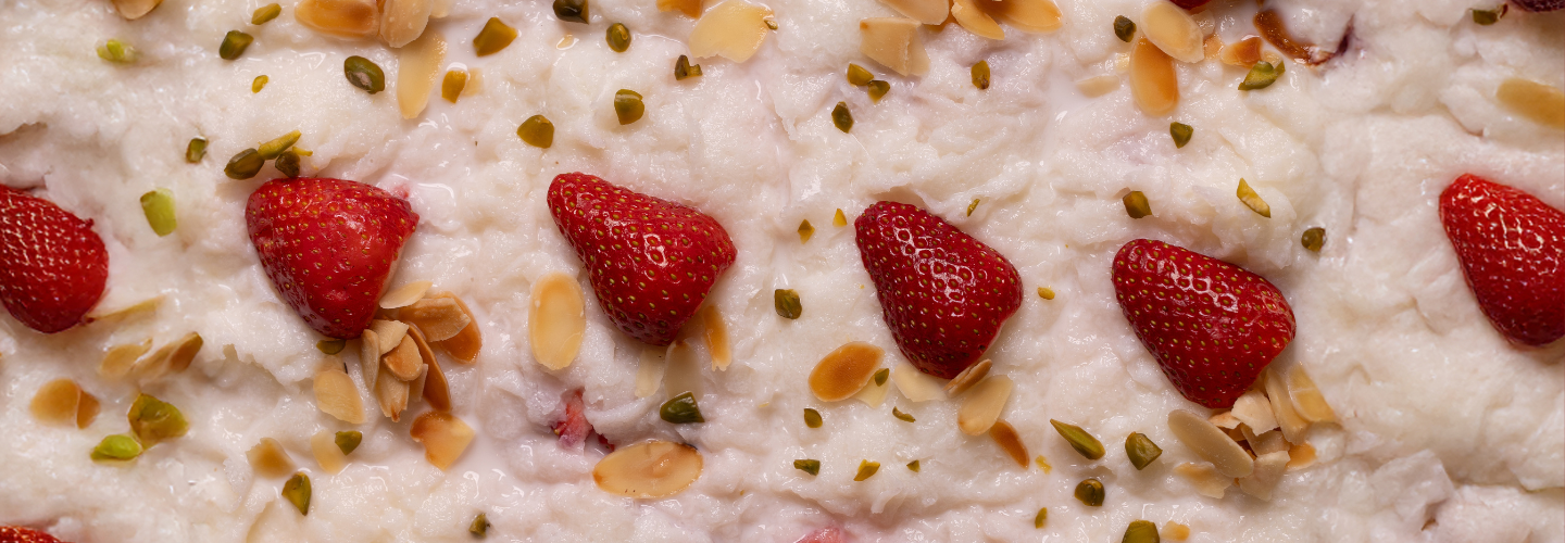 Milk pudding topped with strawberries, almonds and pistachios